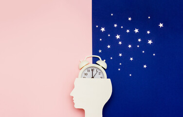 Silhouette of human and alarm clock on pink and blue backgrounds decorated with silver confetti....