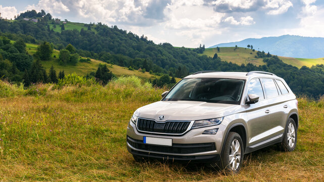 mizhirya, ukarine - AUG 08, 2020: suv on a hillside meadow. beautiful summer landscape on a sunny day. travel countryside and summer vacation concept