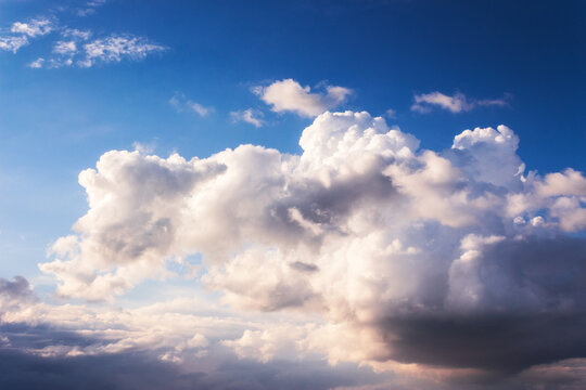 white cumulus clouds on a blue sky. beautiful nature background in evening light