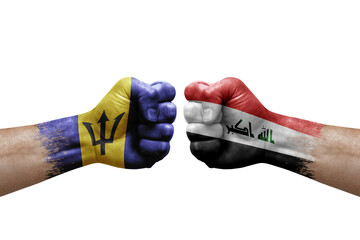 Two hands punch to each others on white background. Country flags painted fists, conflict crisis concept between barbados and iraq