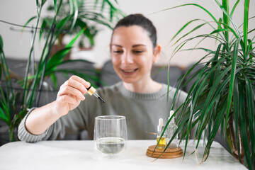Woman drinking glass with Chlorophyll water, antioxidant beverage. Healthy lifestyle 