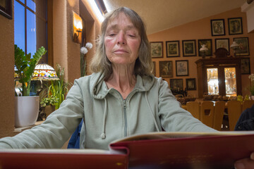 frau liest in restaurant die speisekarte