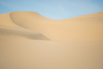 Fototapeta na wymiar Sandy dune against a blue sky