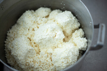 Cottage cheese in saucepan. Food in dining room. Cooking lunch in school kitchen. Dairy products. Chef's job.