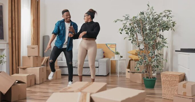 A couple in love moves into a new apartment, the removal of all the cardboard boxes, a new chapter in life, buying, renting a house, the boy along with the girl dance with joy