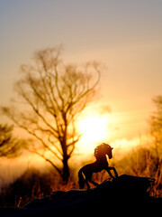 馬のフィギュアと朝焼け