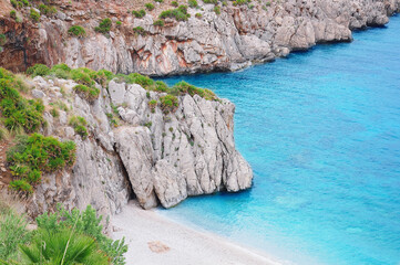 Fototapeta premium Colorful cliffs by the water edge. Natural reserve Zingaro. Sicily. Italy.