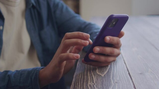 A handsome man is watching something on the phone and looking to the camera 