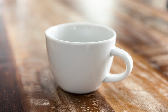 Empty white coffee mug on wood table.