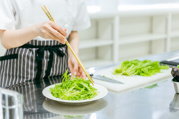 キッチンで野菜を切る女性（盛り付け・顔なし）

