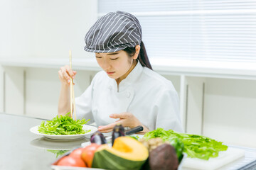 キッチンで野菜を切る女性（盛り付け）
