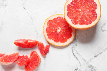 Tasty grapefruit pieces on light background