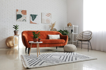Stylish orange sofa with houseplants in modern interior of living room