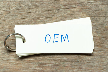 Flash card with handwriting word OEM (Abbreviation of Original Equipment Manufacturer) on wood...