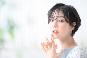 ハッとしてお肌が気になる美人なショートカットの女性　コピースペースあり　アップ