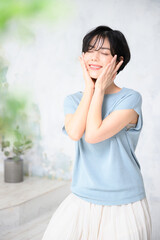 Beautiful Japanese woman with her hands on her face, easy to use for beauty purposes, with vertical copy space and front bokeh.