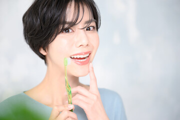 メインビジュアルにも！歯ブラシを持つ美しい日本人女性のアップ　右にコピースペースあり
