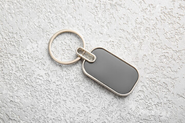 Stylish steel keychain on grey background