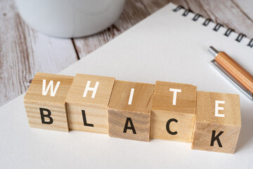 「WHITE」「BLACK」と書かれた積み木、ペン、ノート、コーヒーカップ