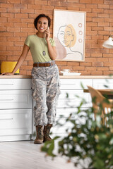 African-American female soldier talking by phone at home
