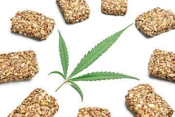 Protein bars with hemp seeds and leaf on white background, closeup