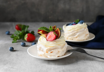 Plate of tasty Pavlova cakes with berries on table