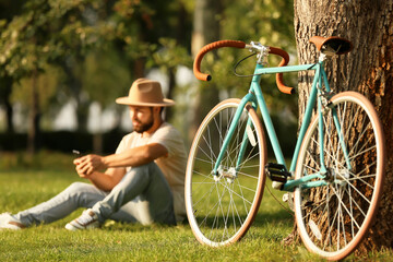 Stylish bicycle near tree in park - obrazy, fototapety, plakaty