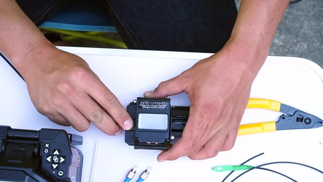 Wire connection with Fiber Optic Fusion Splicing machine,fiber optic cable splice machine in workTechnician Fiberoptic Fusion Splicing. Worker connecting for Cable Internet signal 