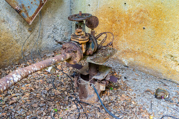 abandoned old rusty valve on a water pipe coming out of a well with a submersible water pump