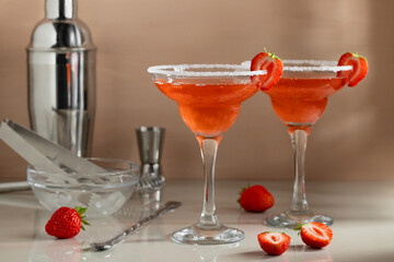 Fresh homemade strawberry margarita cocktails with bar tools on the table. Preparing summer refreshing cocktails