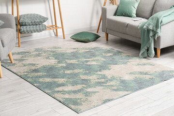 Soft stylish carpet on grey wooden floor in living room interior