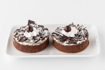 Close up of two gourmet chocolate pastry cakes on a small white plate.