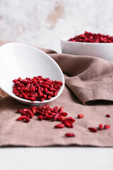 Bowls with dried barberries on light background