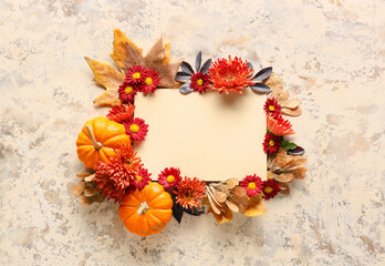 Autumn composition with blank card, chrysanthemum flowers and pumpkins on grunge background