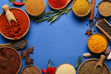 Frame made of aromatic spices on blue background, closeup