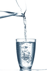 Pouring of clear water in glass isolated on white
