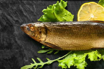 Smoked herring fishes on black background, closeup