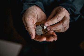 dirty hands of an old woman holding coins. a crisis. default. poverty