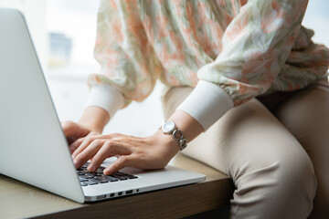 Naklejka premium Unrecognizable Asian young woman using laptop computer or notebook computer to search the news and information.