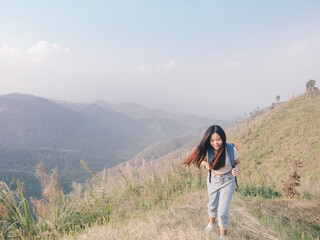 wanderlust and travel concept from Happy asian young woman walking trail in mountain with amazing view. Trekking mountain on National park in Thailand.