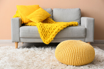 Yellow pouf on fluffy carpet in living room
