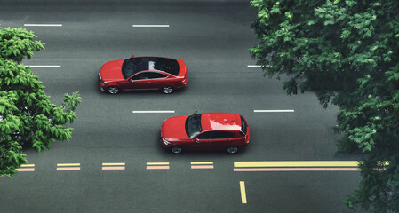 top view Two red cars cruising on a city street with trees.