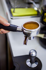 tempering coffee by hand in a coffee shop