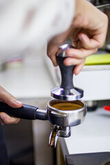 tempering coffee by hand in a coffee shop