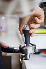 tempering coffee by hand in a coffee shop