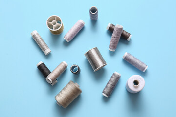 Fototapeta premium Thread spools on blue background