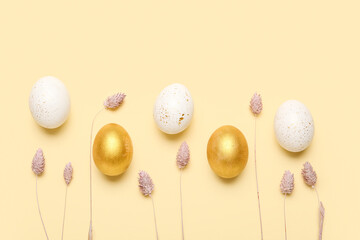 Easter eggs and beautiful dried flowers on color background