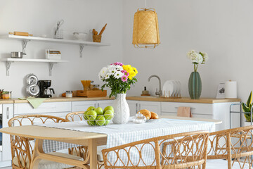 Vase with beautiful Chrysanthemum flowers on dining table in kitchen