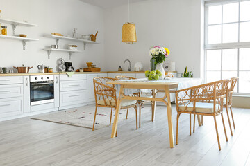 Interior of modern kitchen with dining table and beautiful Chrysanthemum flowers