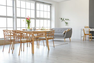 Vase with beautiful tulip flowers on dining table in room